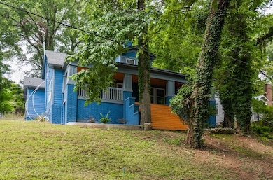 View of front of house featuring a porch, a front lawn, and brick siding