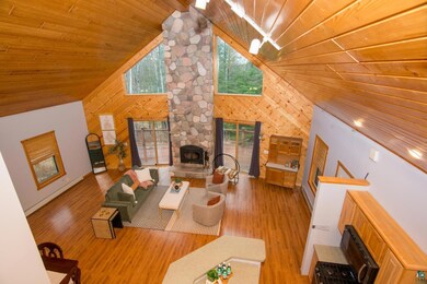 Living area featuring a fireplace, wood walls, hig