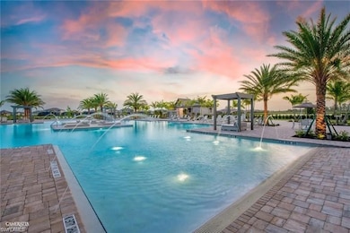 Pool at dusk with a community pool and a patio