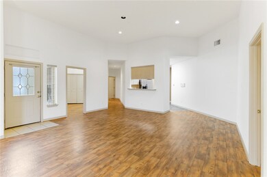 Entryway into large Living room, looking at Kitchen and hallway to two bedrooms and one bathroom. Door on the right side of the picture is entry into the master bedroom