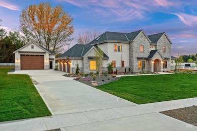 View of front of property with stone siding, detached RV garage, and concrete driveway