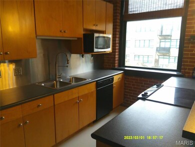 Kitchen with backsplash, dishwasher, and sink