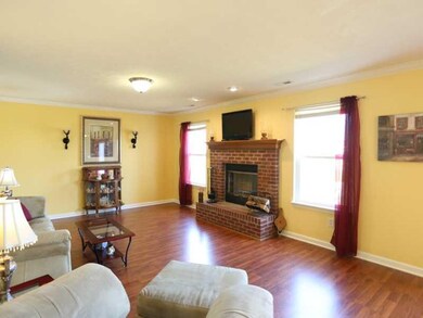 Family Room. The spacious family room features warm laminate flooring and a wood burning, brick fireplace.
