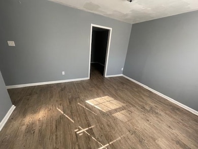 Empty room with dark wood-type flooring