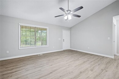 Unfurnished room featuring vaulted ceiling, wood finished floors, and ceiling fan