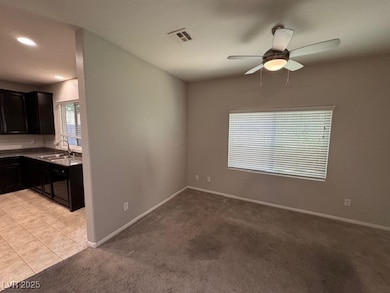 Empty room featuring a ceiling fan, light carpet,