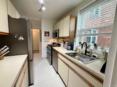 Kitchen with stainless steel appliances, light countertops,  and light tile  floor