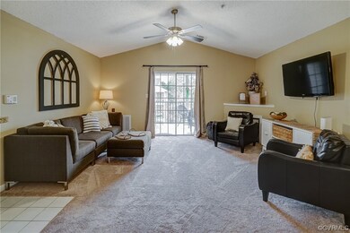 Carpeted living room featuring vaulted ceiling, a