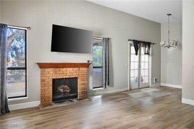 Unfurnished living room featuring a chandelier, wood finished floors, and a fireplace