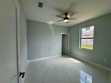 Empty room featuring marble look tiles and a ceiling fan