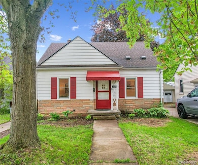 Bungalow-style home with stone siding, a shingled roof, and a front yard