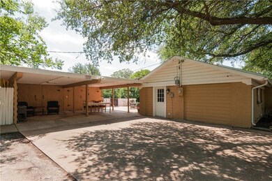 Another view of the driveway and covered carport.