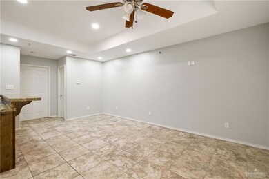 Unfurnished room with ceiling fan and a tray ceiling