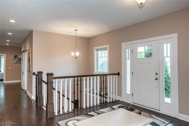 Foyer with dark wood-type flooring and a notable chandelier