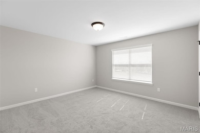 Empty room featuring light carpet