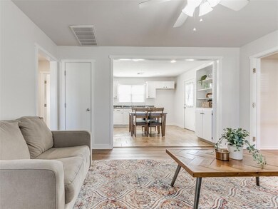 Living room with ceiling fan and light wood-type f