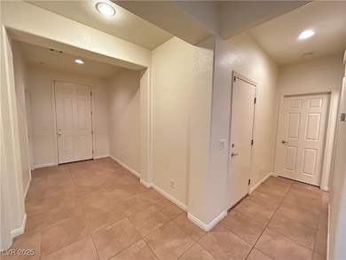 Hallway featuring light tile patterned floors, bas