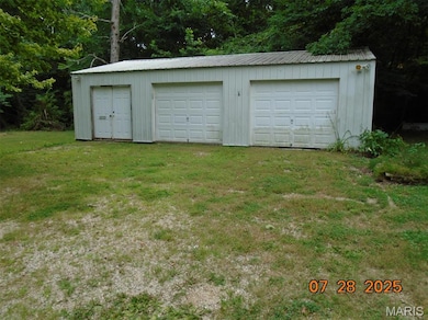 Detached garage with view of wooded area