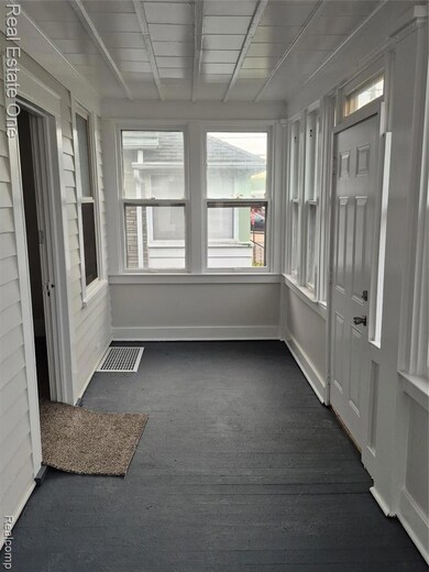 Unfurnished sunroom with baseboards and beam ceiling