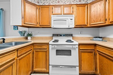 Kitchen with a sink, white appliances, and light c