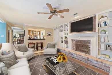 Virtually Staged: One of the standout features is the charming brick fireplace with a white mantle and built-in shelving on both sides.