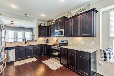 Next we enter the Kitchen, the heart of the home!  Beautifully designed kitchen from the wood floors, the 36 inch designer cabinets with crown molding to the under-cabinet lighting!  You will also find beautiful granite counter tops and tile back splash.