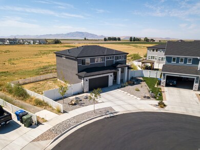 View of front facade with driveway, a fenced backyard, a view of rural / pastoral area, a garage, and a mountain view