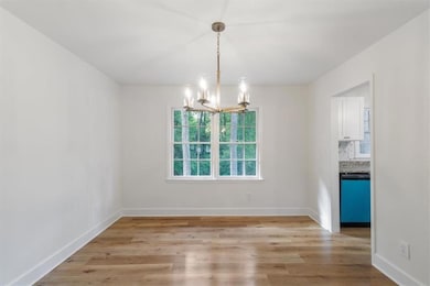 Spare room featuring a chandelier and light wood-style floors