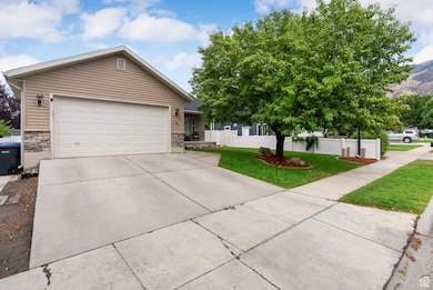 Single story home featuring driveway, an attached garage, and stone siding