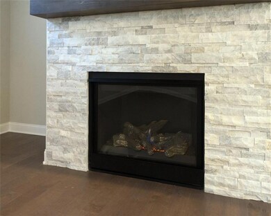 Details with a fireplace, baseboards, and wood finished floors