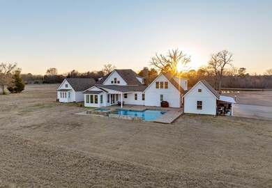 Back of property at dusk featuring a pool with con