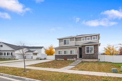 View of front of house with stone siding and concrete driveway