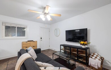 Living area featuring a ceiling fan, baseboards, 
