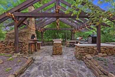 Amazing outdoor kitchen, over looking the creek. With a custom made wood burning pizza oven, gas grill, gas stove top, smoker, custom made beverage cooler table with granite, tons of prep space.