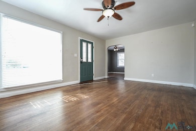 Unfurnished room with ceiling fan and dark wood-style flooring