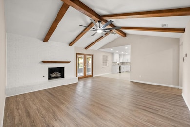 Unfurnished living room with a fireplace, french doors, and light wood-style floors