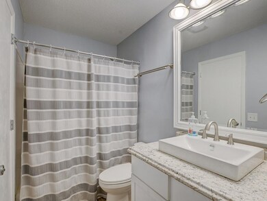 The full bathroom is modern and bright, with a lar