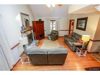 Living area with hardwood floor, chair rail, and p