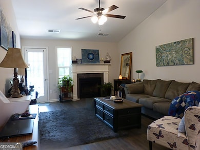 This inviting and expansive family room is a true highlight, boasting a soaring vaulted ceiling that enhances the sense of openness. A cozy fireplace provides warmth and ambiance, while direct balcony access allows for seamless indoor-outdoor living.
