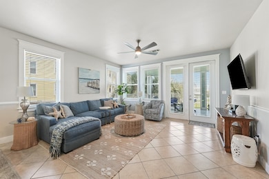 The main living space is filled with natural light from walls of windows, offering stunning beach views and a seamless flow to the balcony.