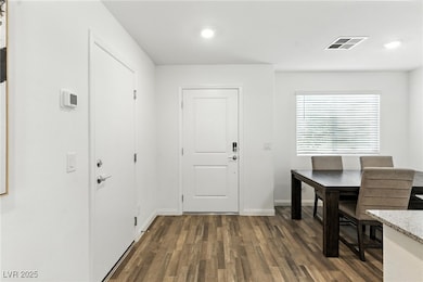 Dining area with dark wood-style flooring and recessed lighting