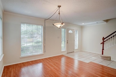 Foyer featuring crown molding, a textured ceiling