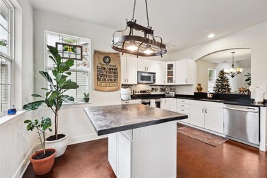 Kitchen with white cabinetry, appliances with sta