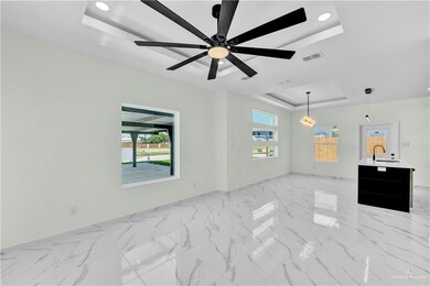 Empty room featuring visible vents, a raised ceiling, marble finish floor, and a healthy amount of sunlight