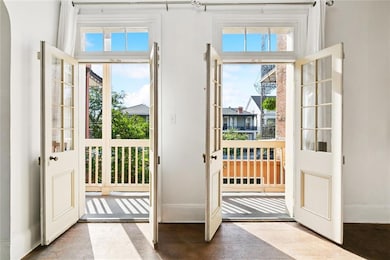 French doors open to a private wrought-iron balcony overlooking the streetcar line and vibrant Rampart Street below.