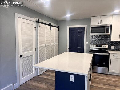 Kitchen featuring a kitchen island, white cabinetr