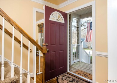The foyer has hardwood flooring, crown and chair r