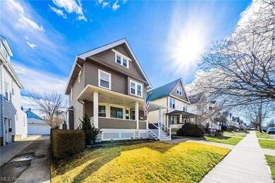 View of front of house featuring a front lawn, covered porch, and a garage