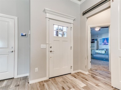 Entryway with crown molding and light hardwood / w