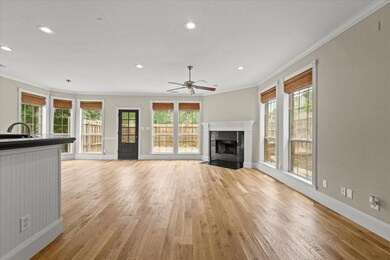 Unfurnished living room with ceiling fan, light ha